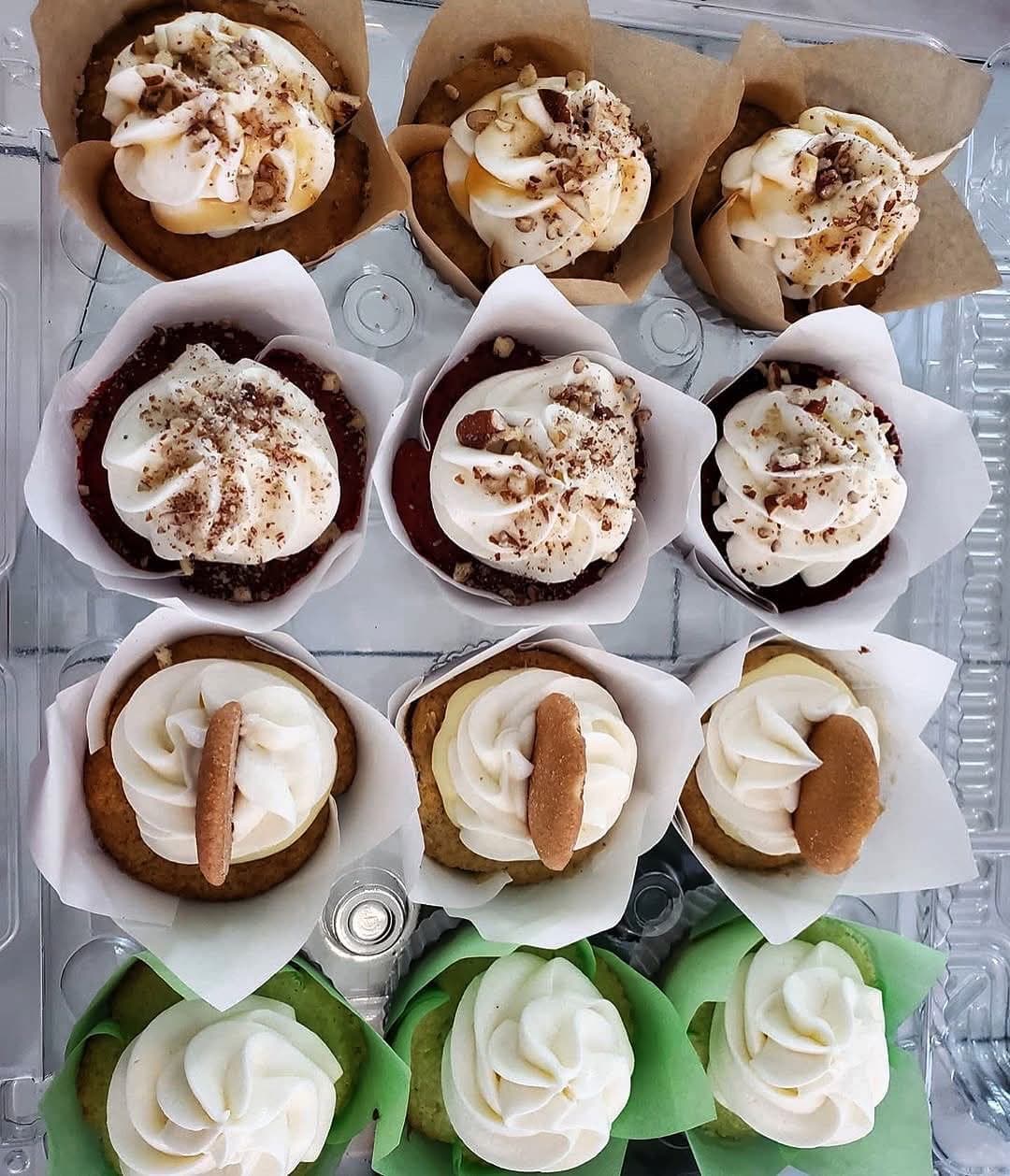 A dozen gourmet cupcakes from Cupcake City 813 in Tampa — banana pudding, red velvet with pecans, and keylime cupcakes in paper wraps