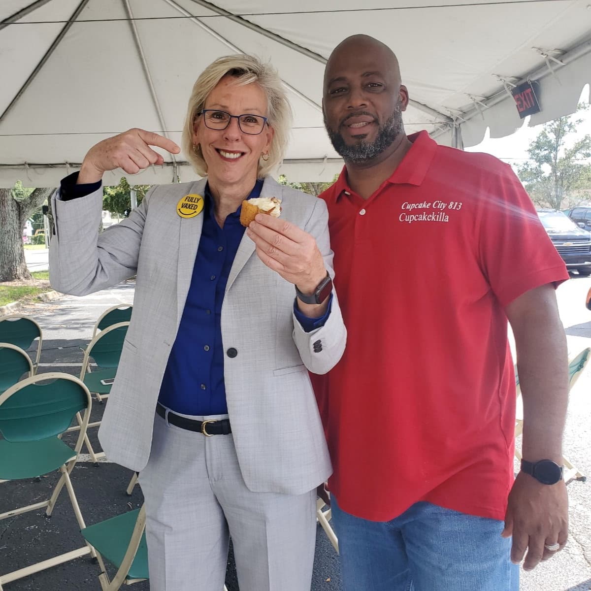 Tampa Mayor Jane Castor pointing at a Cupcake City 813 cupcake she is holding, next to Chef Alvin in his Cupcakekilla polo